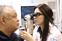 Dr. Kresch, study optometrist, using a portable slit lamp in the community